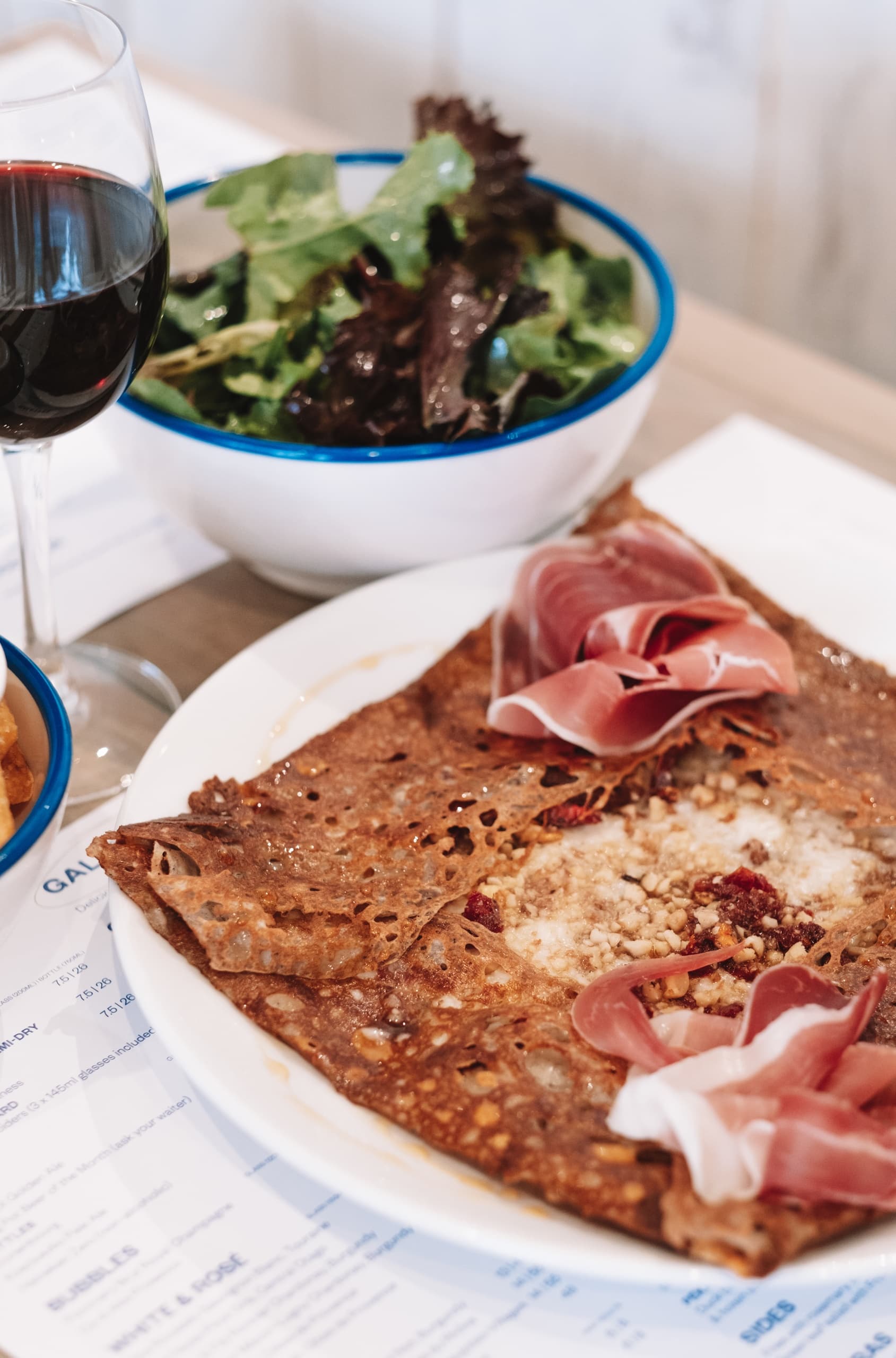 Savory buckwheat galette with prosciutto and salad at cafe
