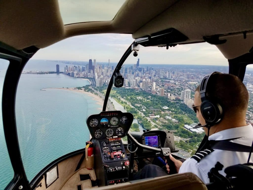 Helicopter pilot flying above Miami coastline with city skyline