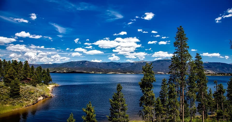 Hiking-friendly mountain lake shoreline with pines and peaks