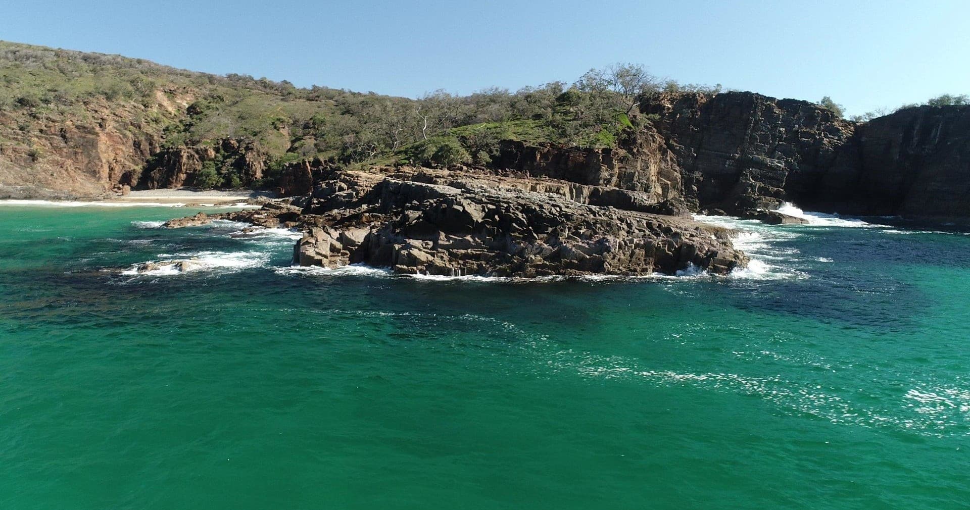 Aerial view of rugged coastline and turquoise ocean cliffs