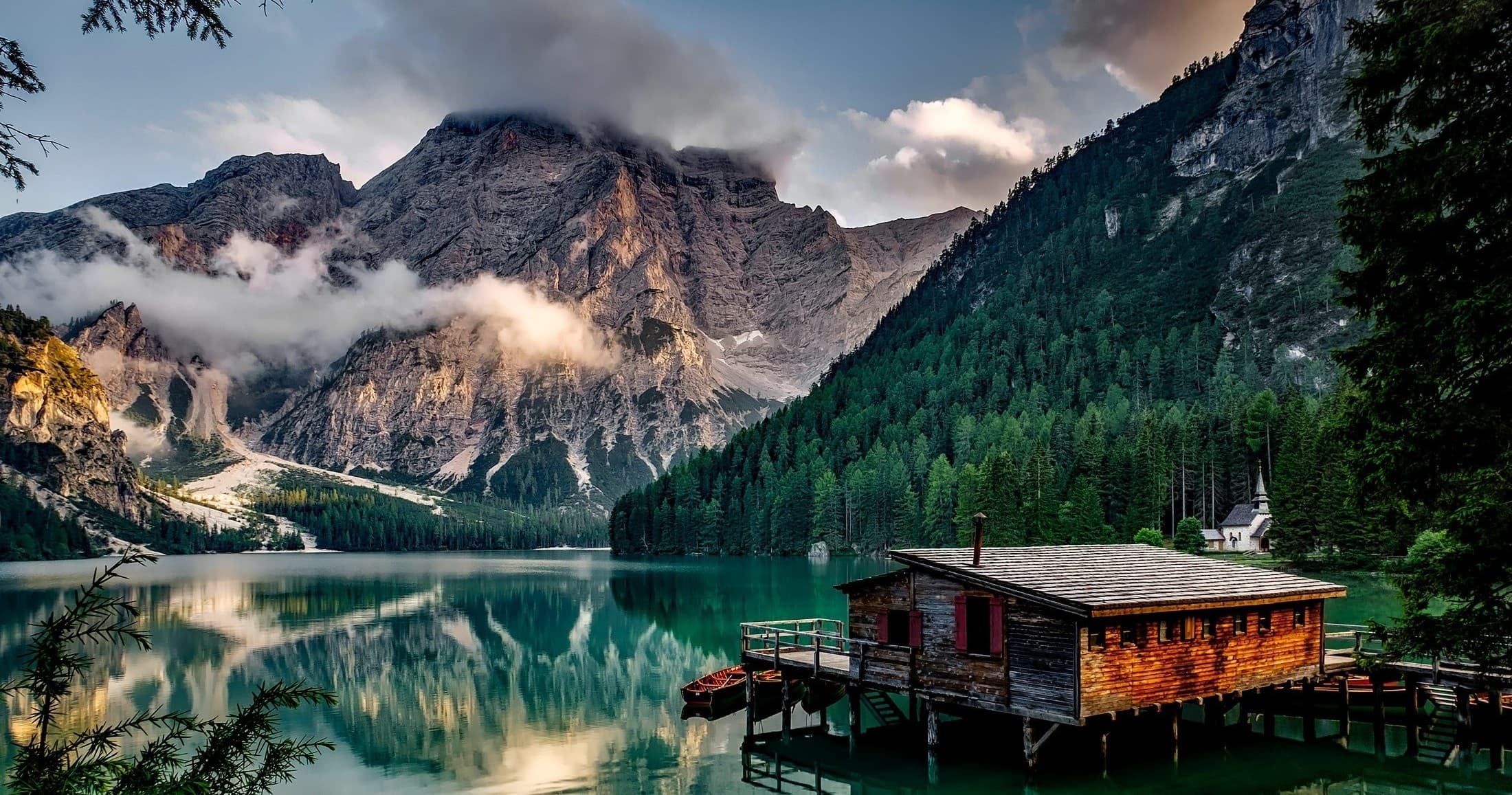 Cabin on alpine lake with mountain reflections, serene kayaking spot