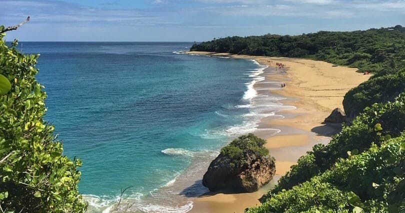 Golden sandy beach with turquoise sea and coastal hiking views