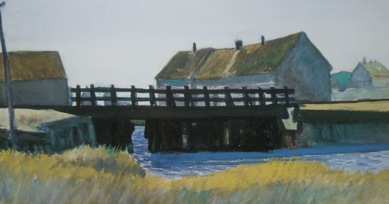 Rustic wooden bridge over river by thatched cottages, tranquil view