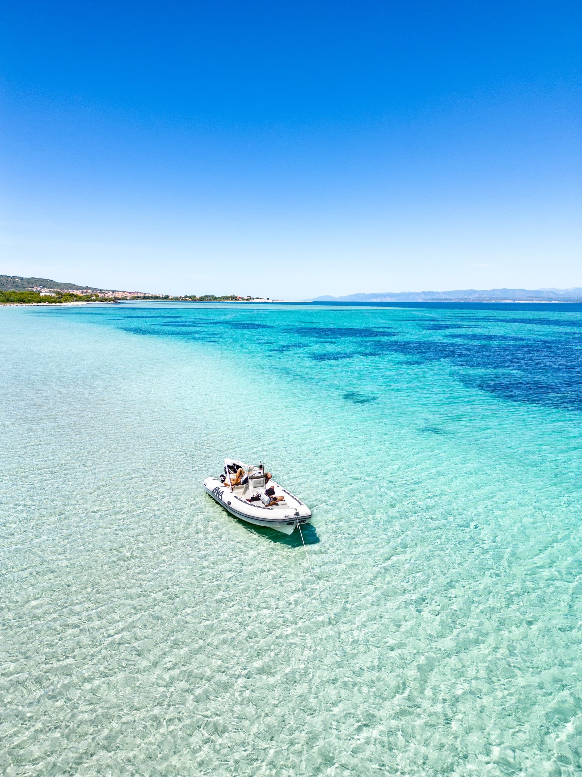 Aerial view of lone boat on turquoise shallow sandbanks, day trip
