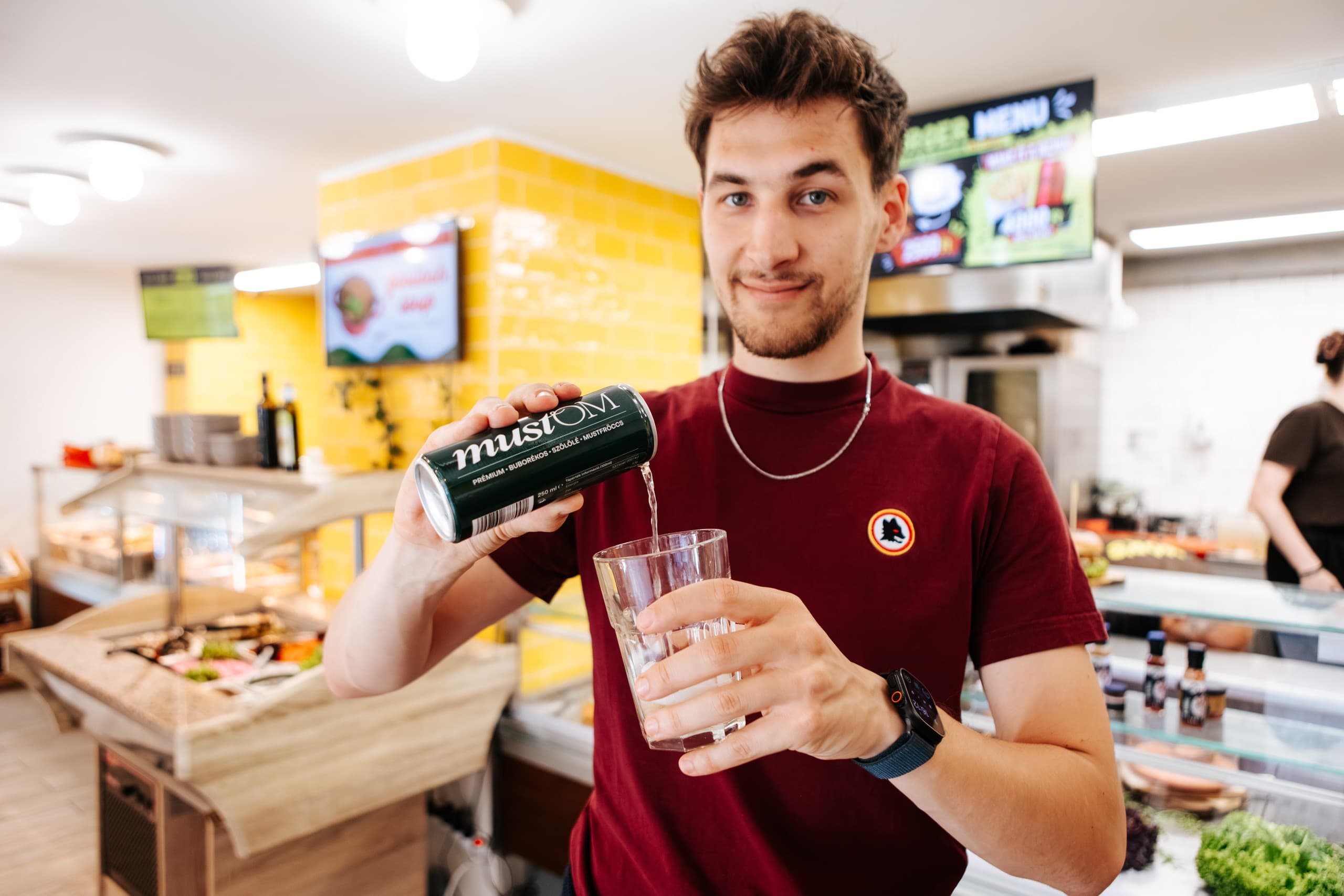 Bartender pouring craft beer at bustling Budapest food market counter