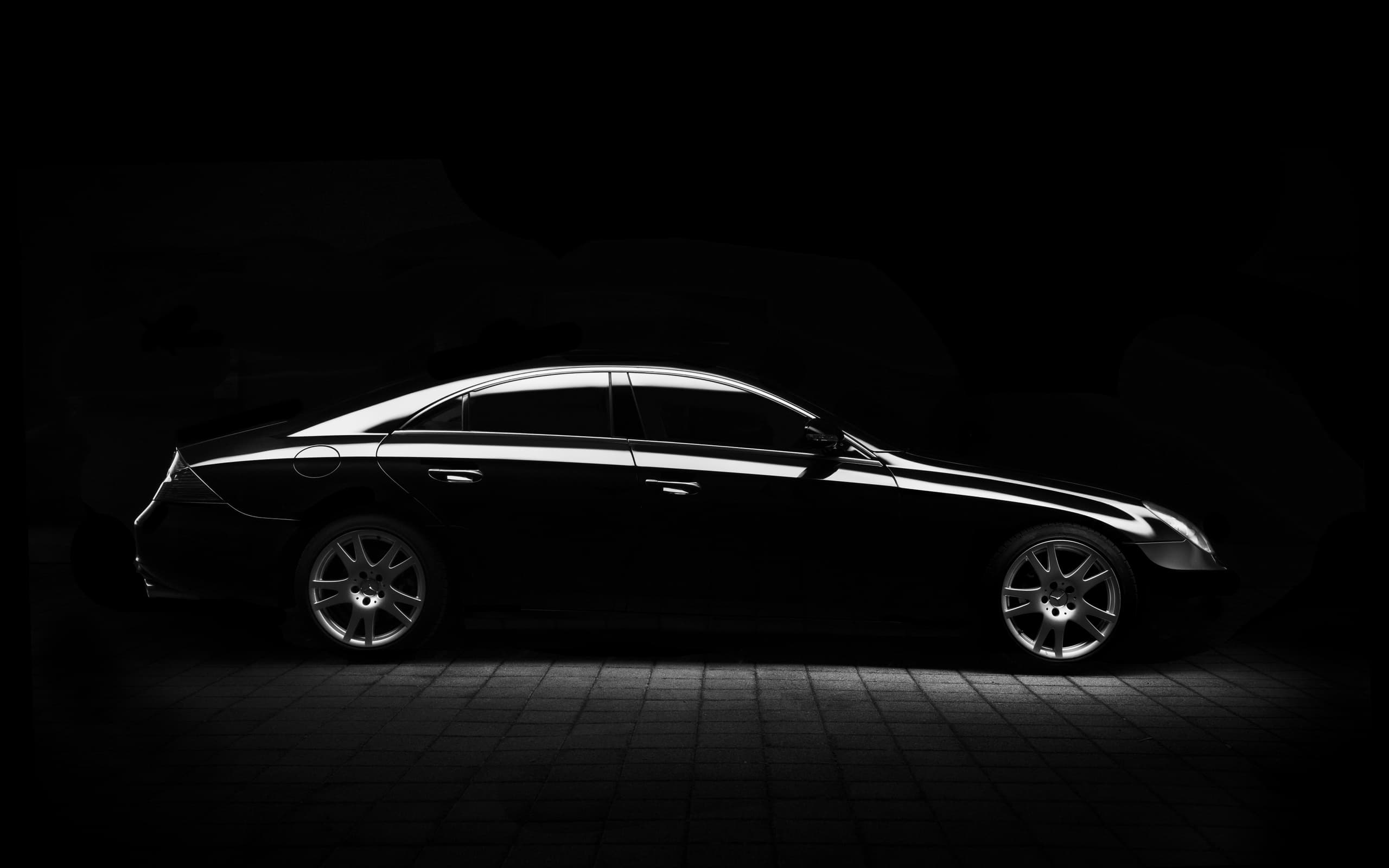 Black sedan silhouette studio shot highlighting vehicle profile