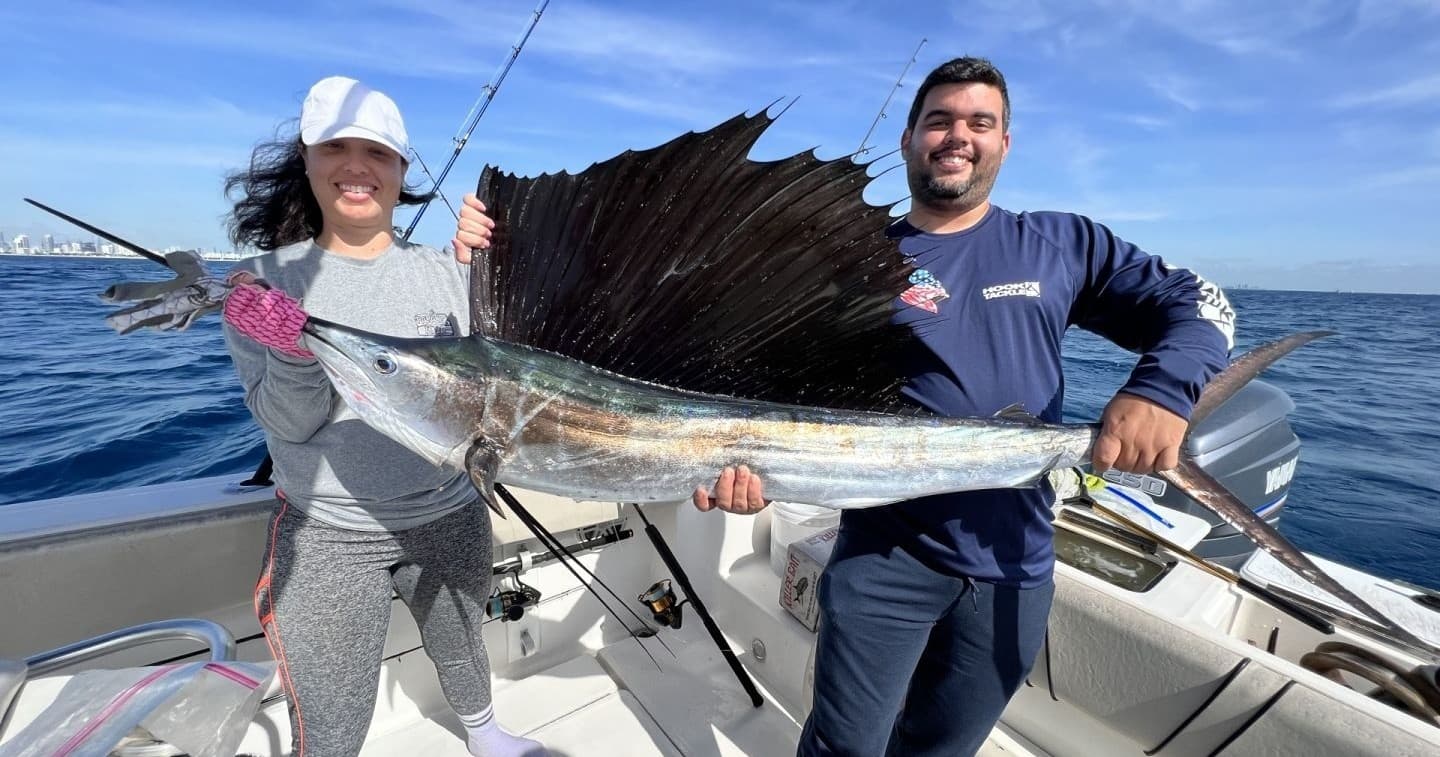 Anglers posing with large sailfish caught offshore on charter
