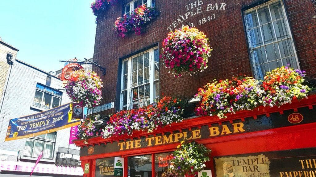 Colorful historic pub exterior with floral displays on Dublin street