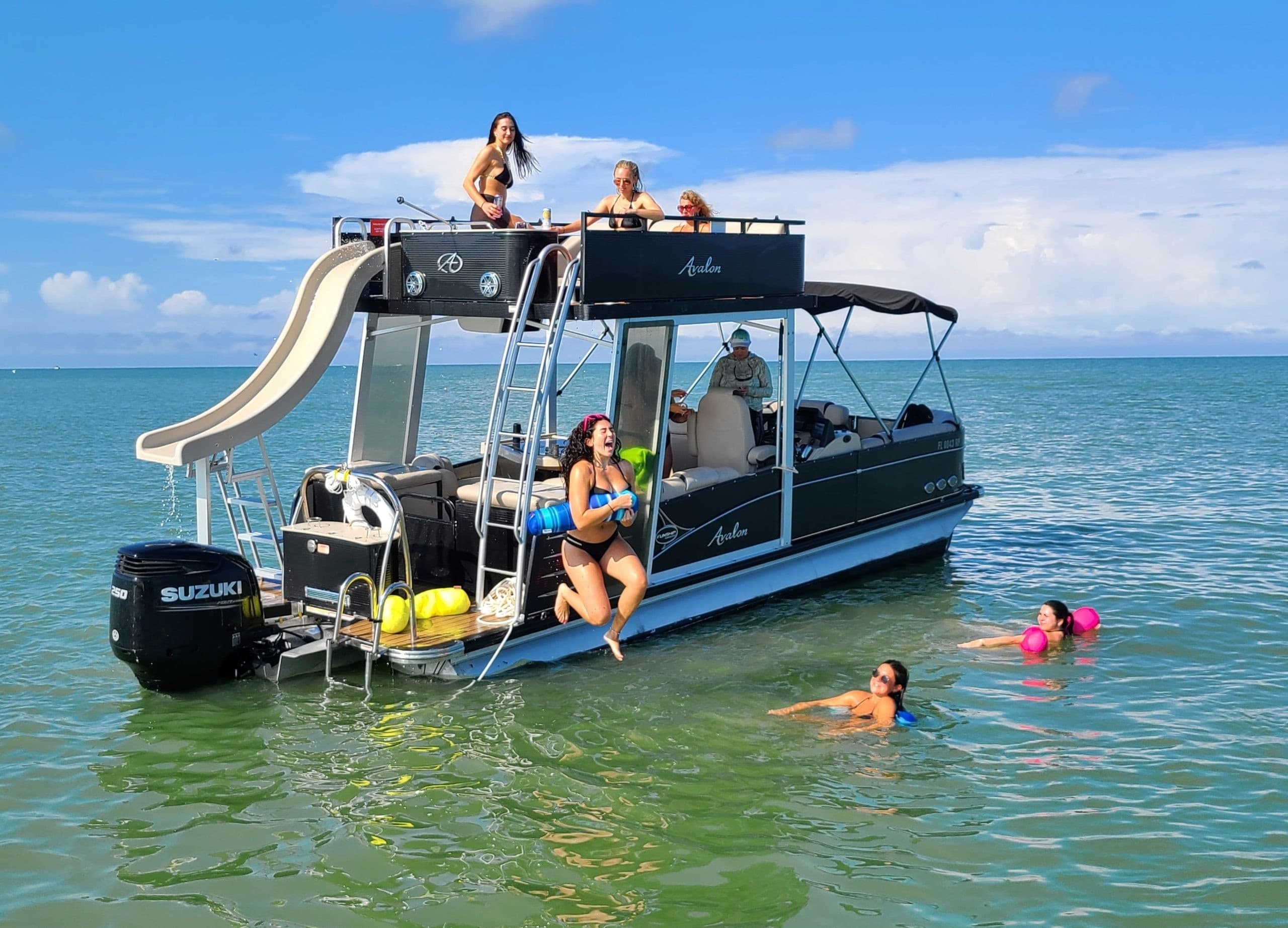 Pontoon boat with waterslide and swimmers in clear coastal waters
