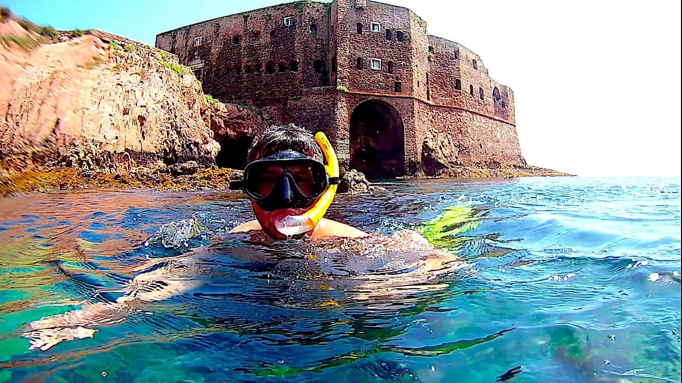 Snorkeler exploring turquoise waters near historic coastal fort ruins