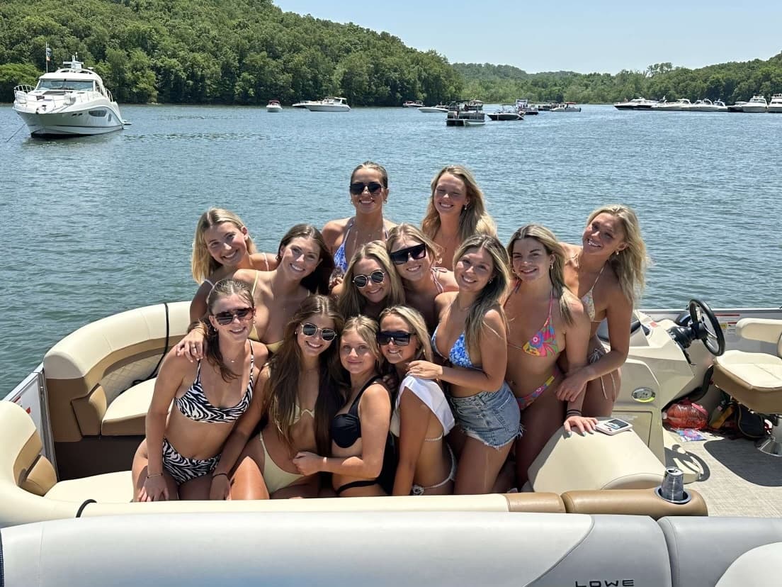 Friends gathered on bow of pontoon boat on sunny lake