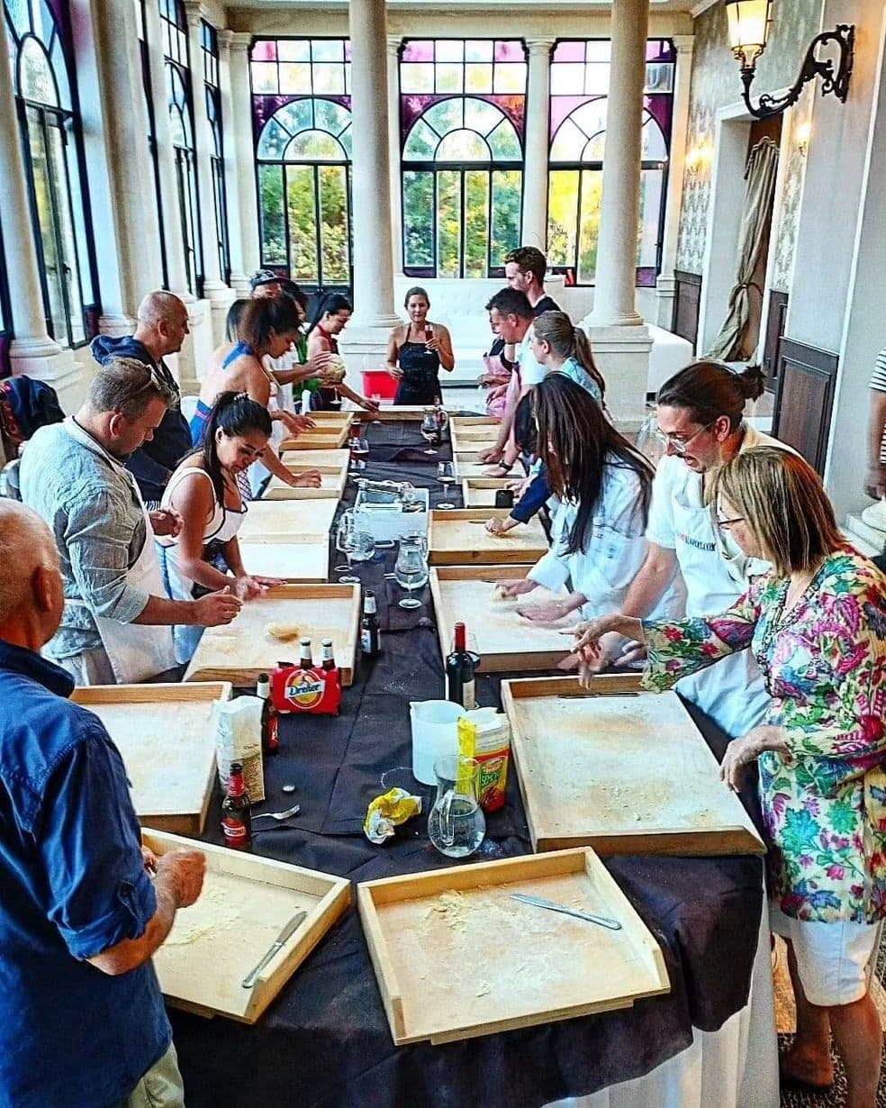 Indoor group pasta-making class in historic villa dining hall