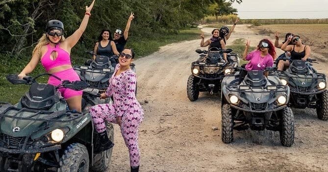 Group riding ATVs on sandy trail near coastal wetlands in Miami