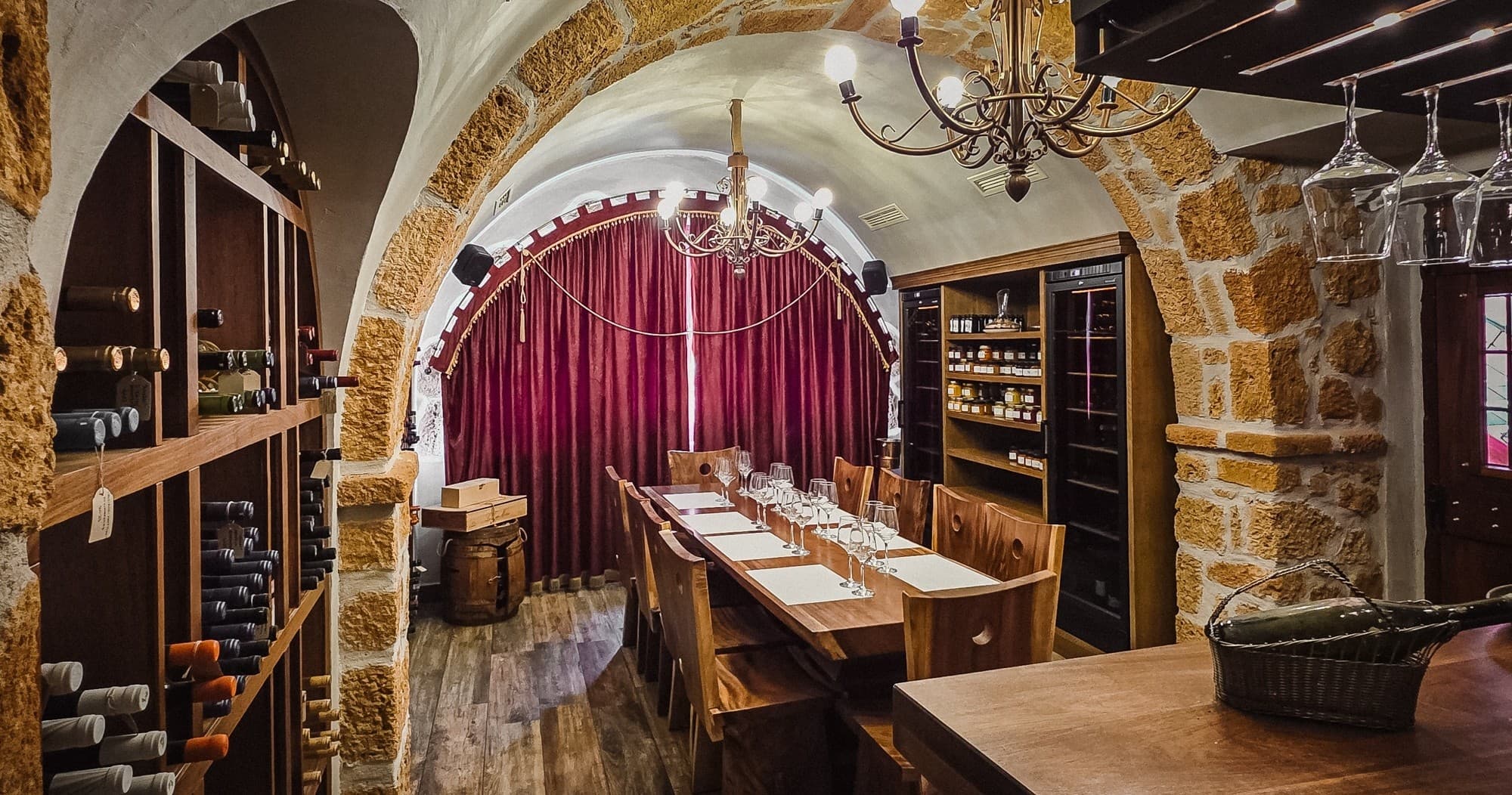 Long table in stone wine cellar with red curtain, communal dining