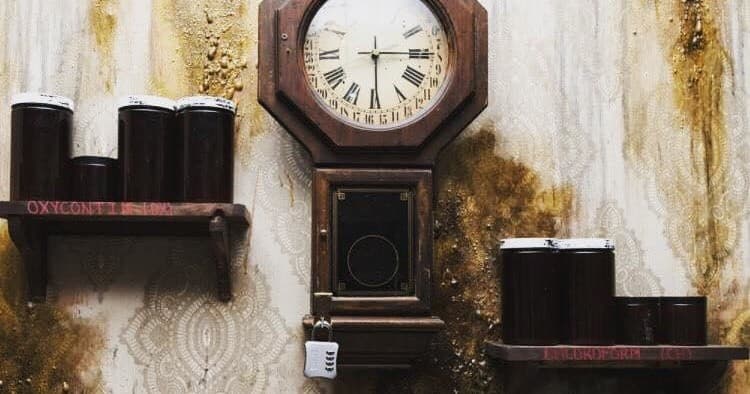 Antique clock and jars on distressed wall in horror set