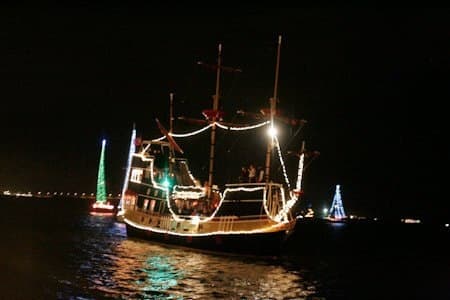Illuminated pirate ship cruising at night in St. Augustine harbor