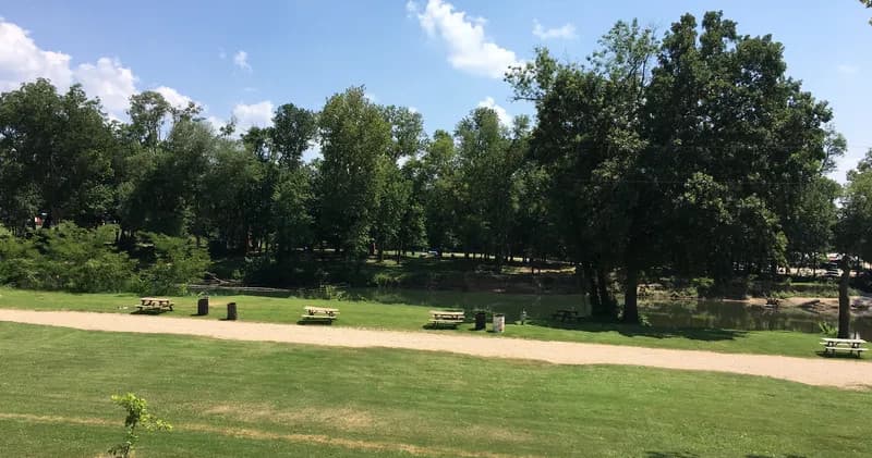 Panoramic grassy campground meadow with river and trees