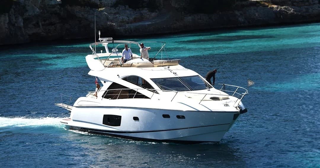 White motor yacht moored near turquoise coastal bay on a sunny day