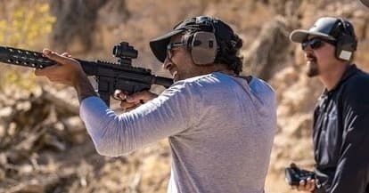 Two shooters aiming rifles during desert tactical training session
