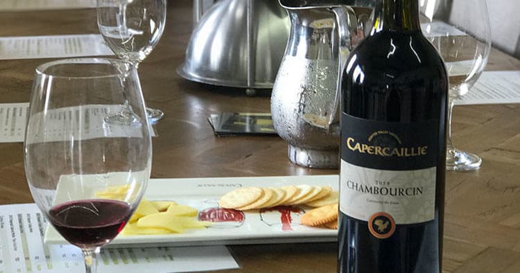 Bottle and glass with cheese board at winery tasting table