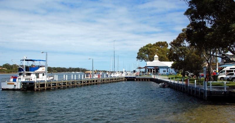 Harbor pier with moored boats and jetty at lakeside town