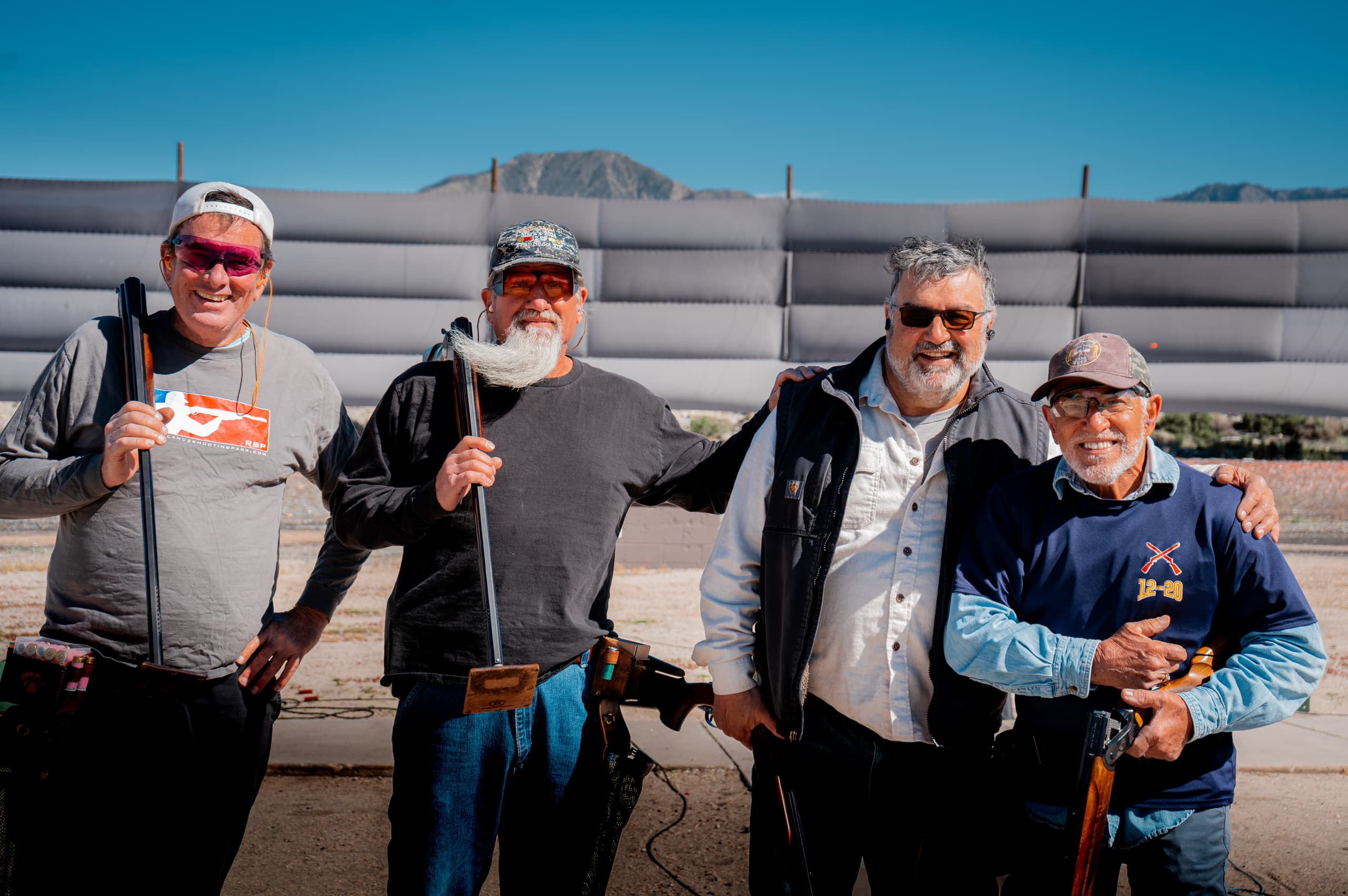 Group of clay shooters smiling outside at shooting park