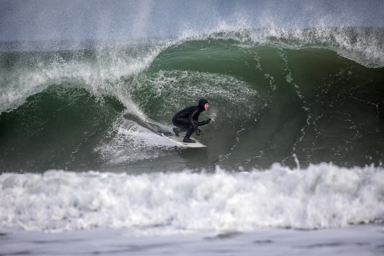 Surfer riding inside powerful breaking wave barrel