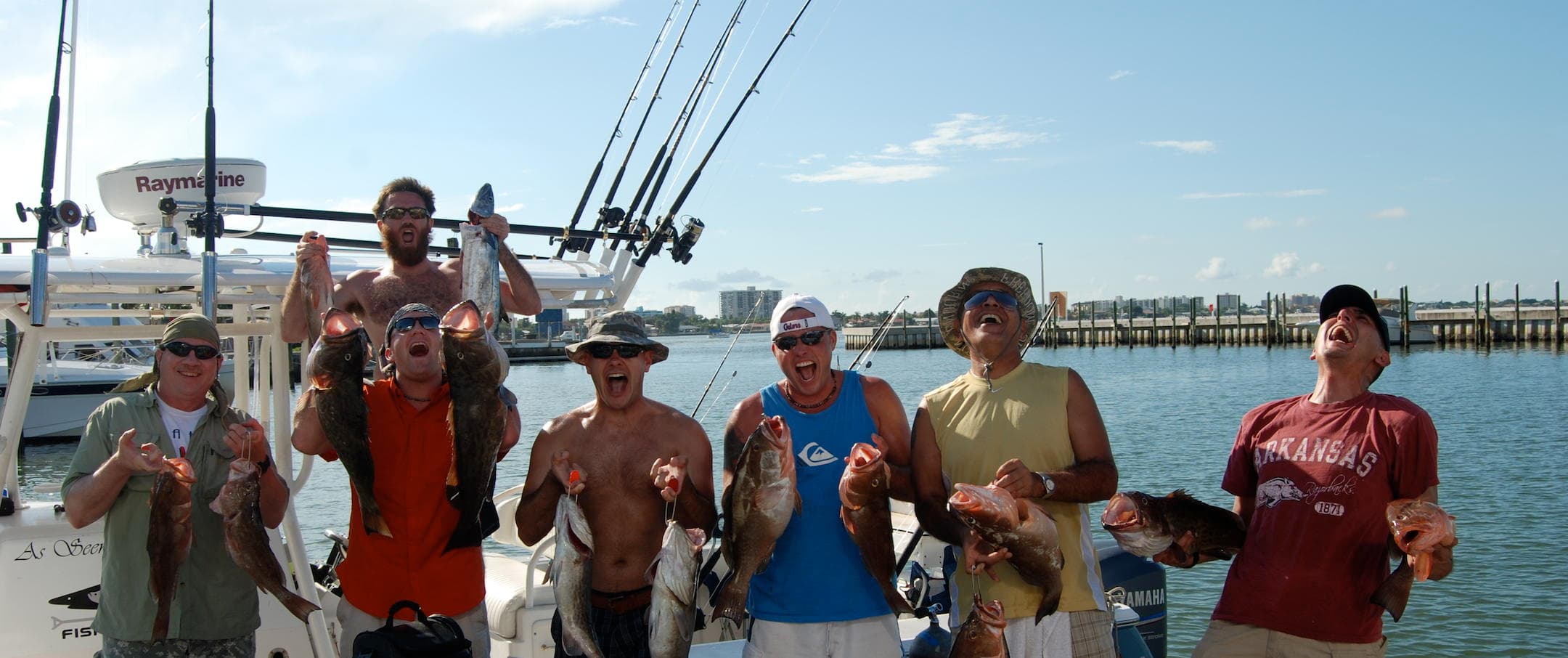 Group of anglers holding redfish and snapper on deck