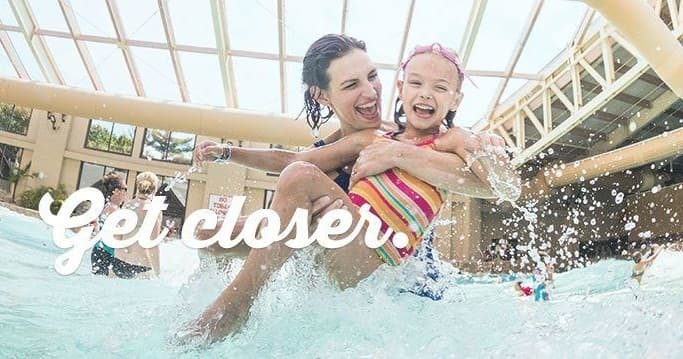Family splashing in indoor wave pool at aquatic resort