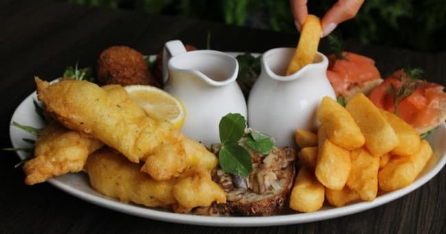 Crispy fish and chips with tartar sauce in casual pub setting