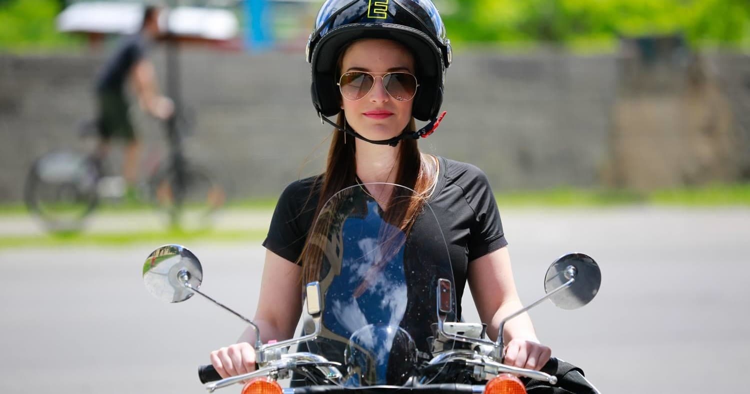 Solo scooter rider wearing helmet on city street in Montreal