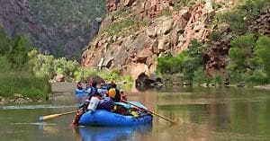 Guided rafting trip passing scenic cliffs and river bends