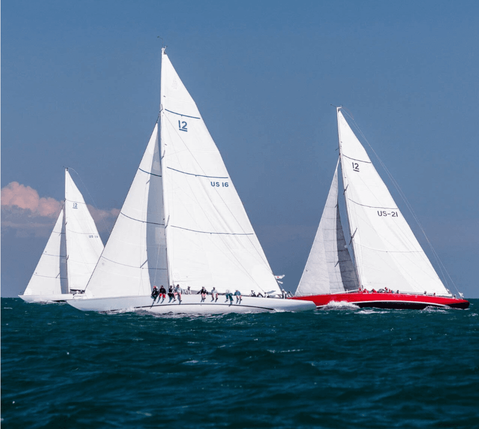 Classic sailing yachts racing on open ocean under blue sky