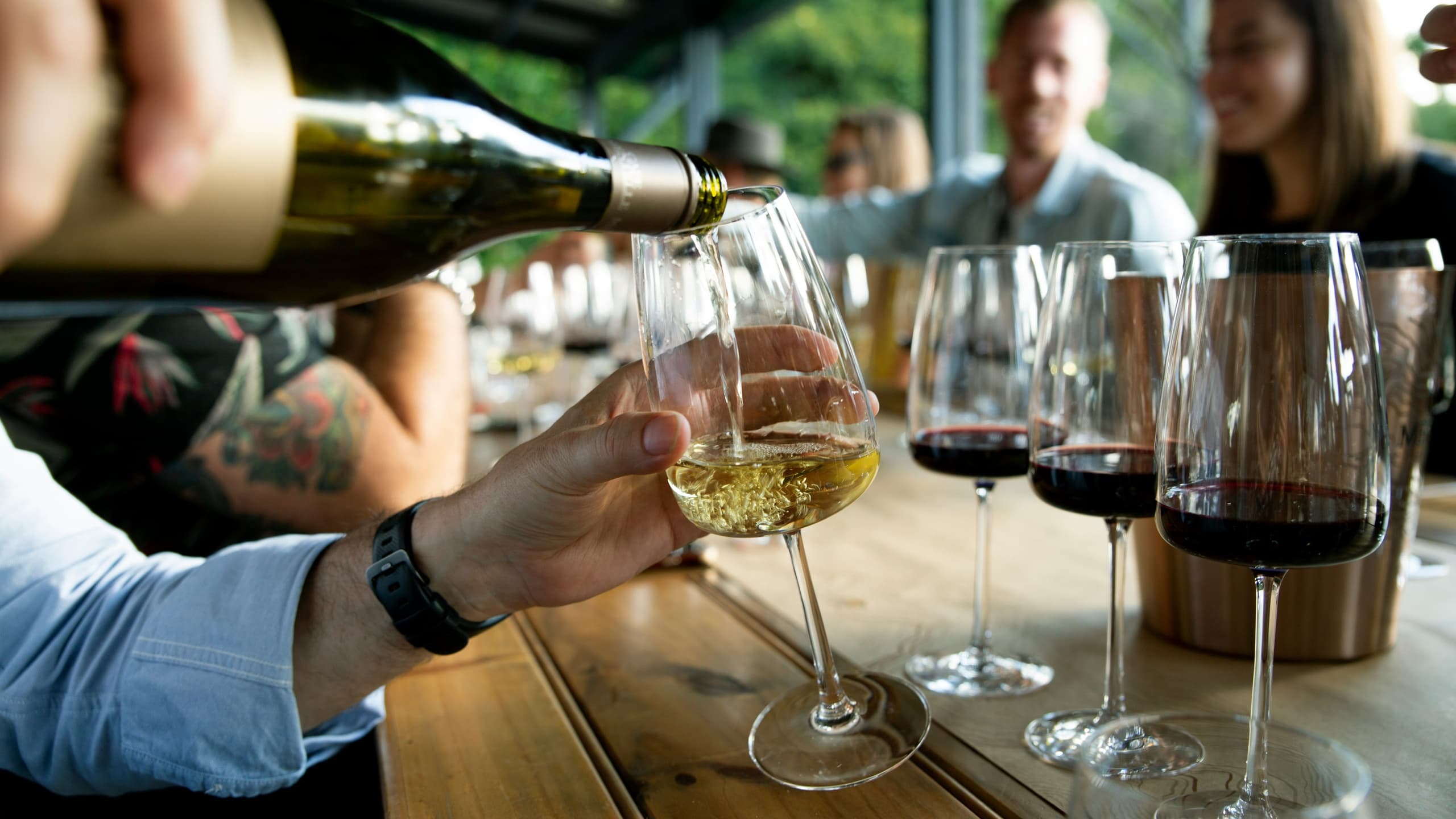 Wine pour and flight tasting at communal table in tasting room