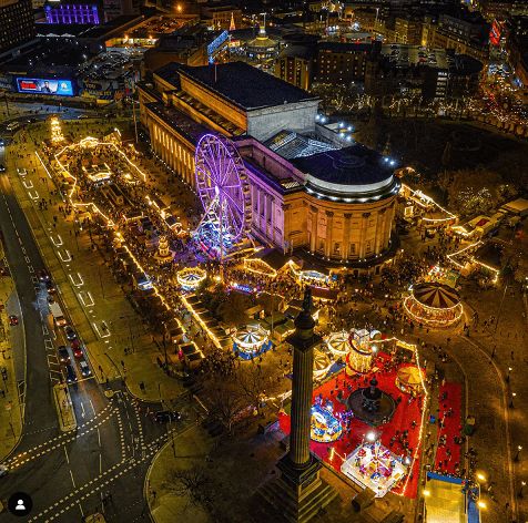 Aerial view of city Christmas market and illuminated ferris wheel