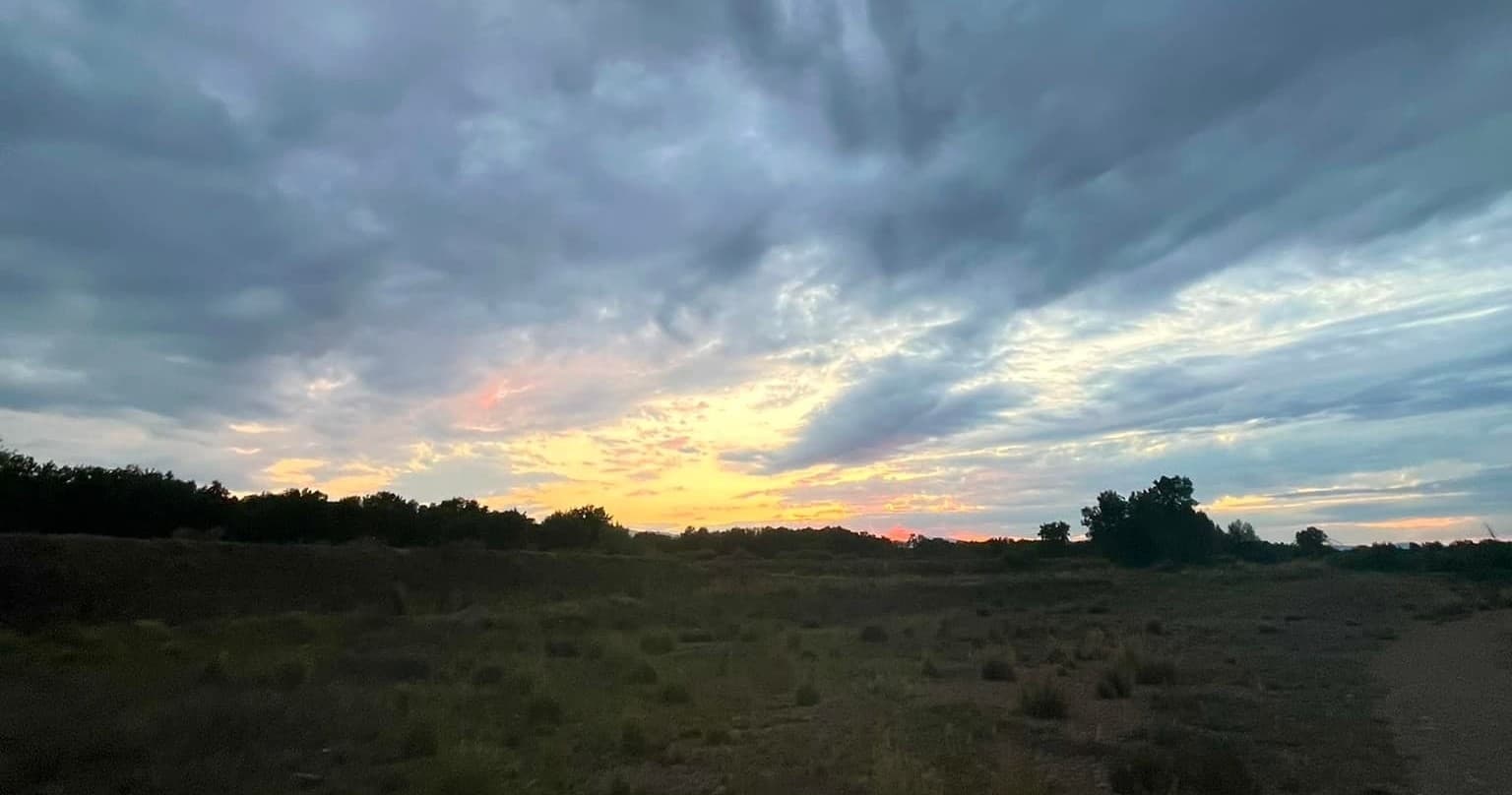 Sunset over prairie with dramatic clouds for scenic hiking