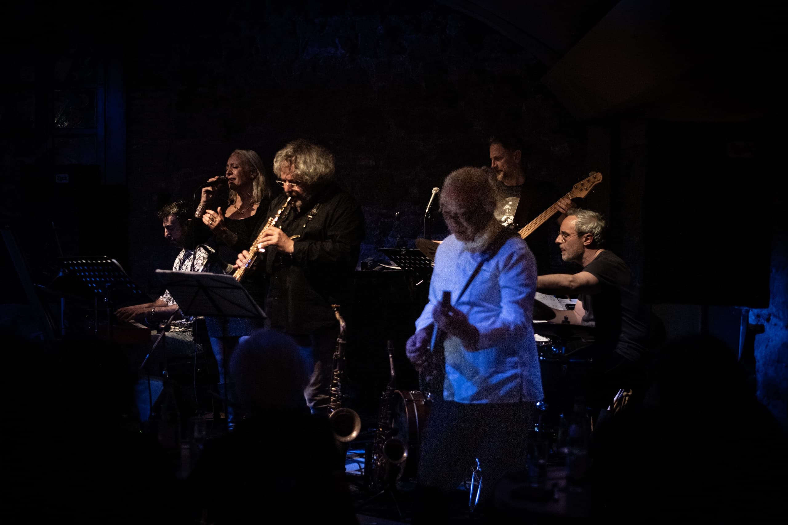 Live band performing on dimly lit stage in intimate indoor music venue