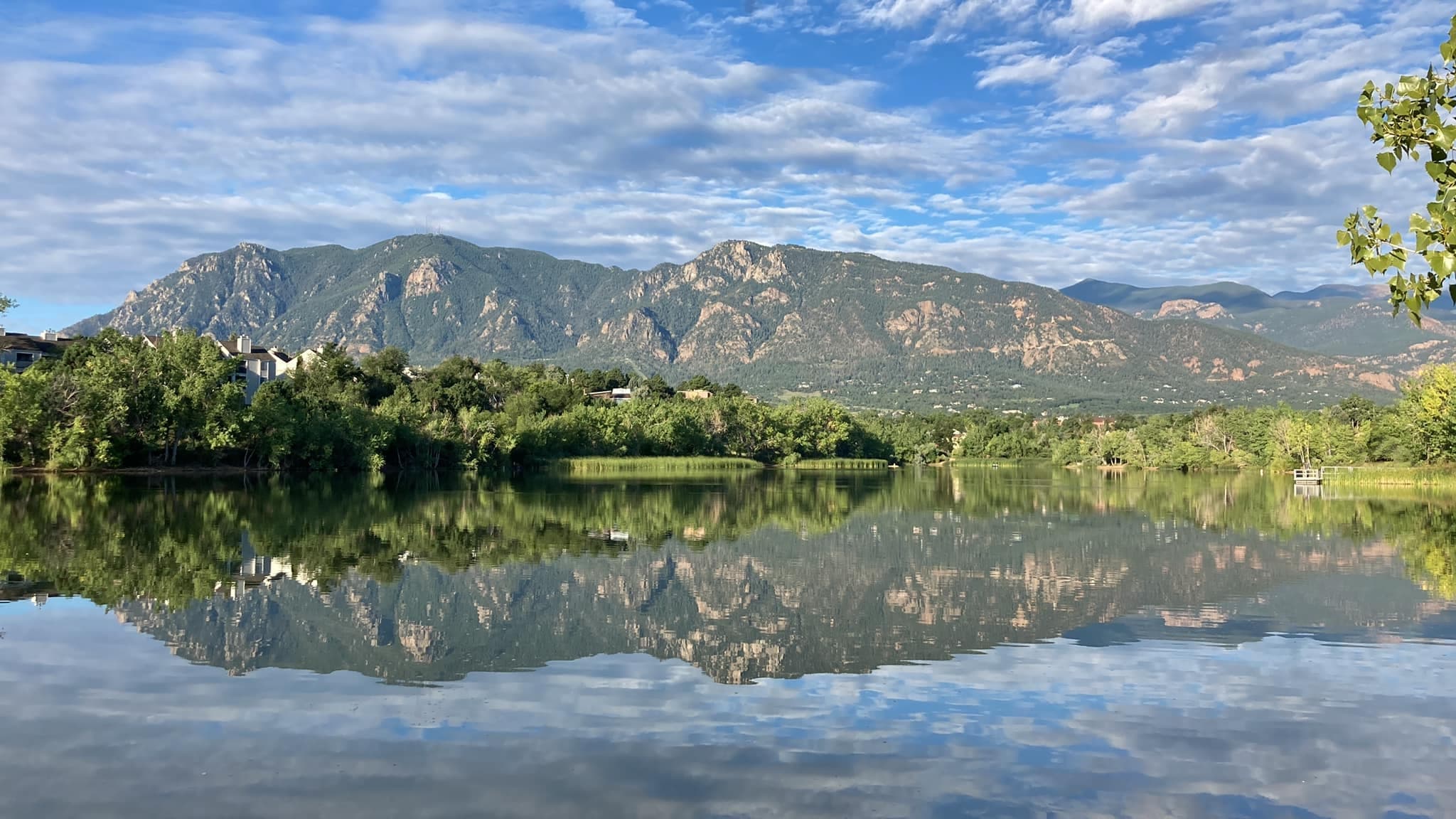 Mountain range reflected in calm lake at Colorado foothills