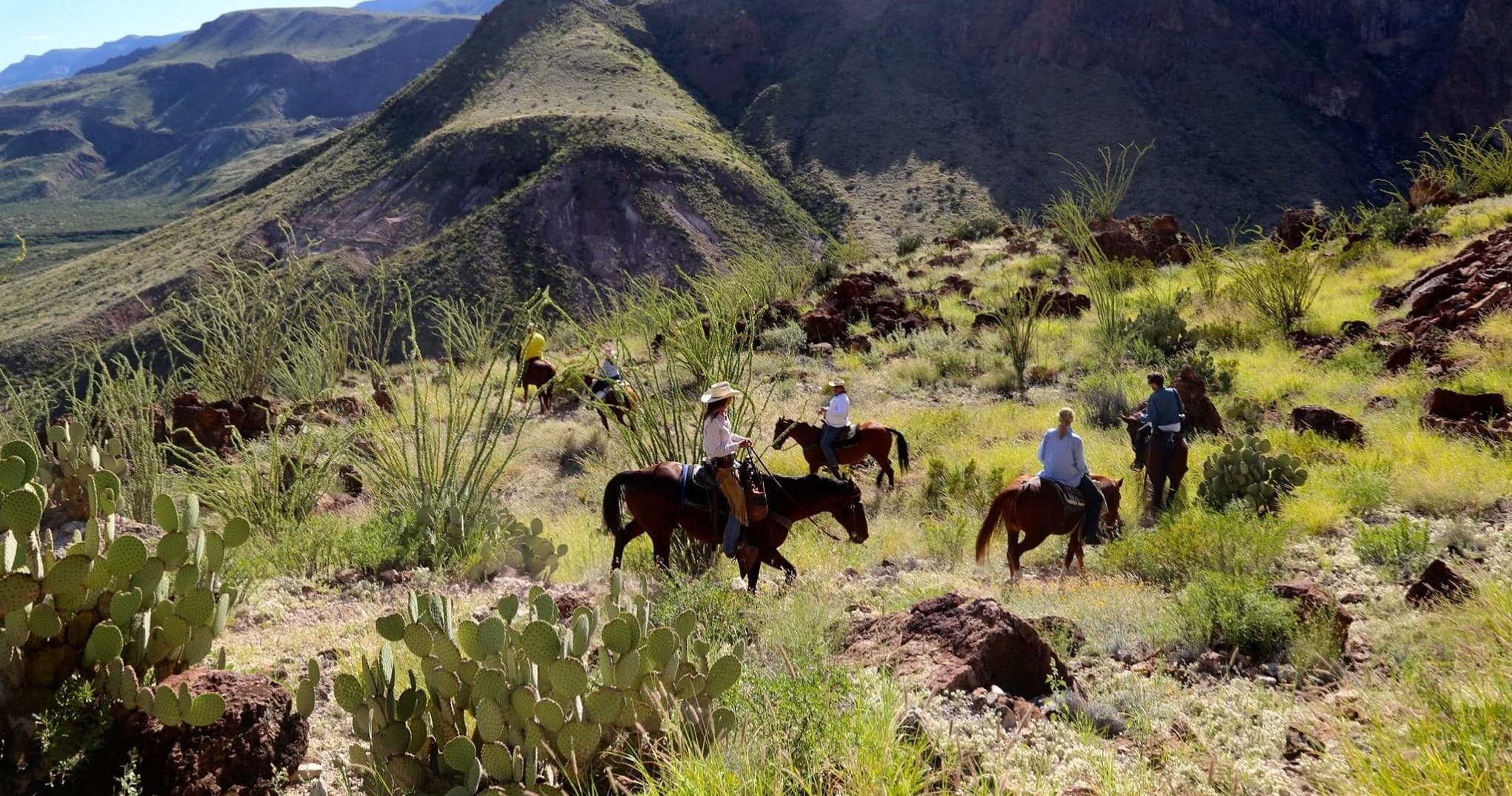 Wide panoramic view of riders on rugged desert ridgeline