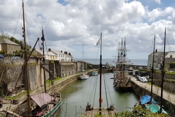 Historic tidal harbor with tall ships and waterfront walkways