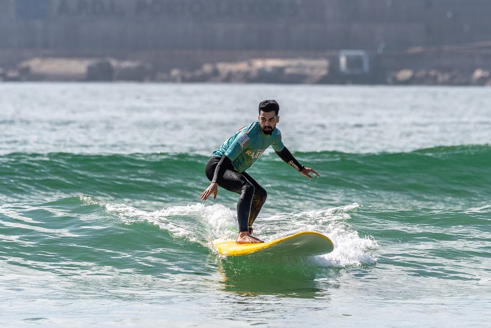 Surfer carving a green wave near coastal shoreline