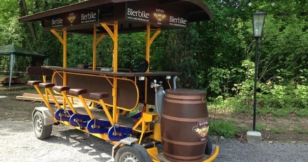 Multi-seat pedal bar bike on wooded trail for group tours