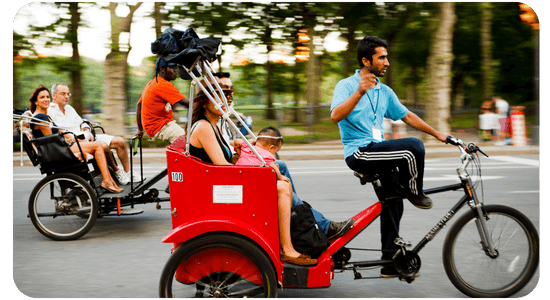 Pedicab drivers transporting passengers on busy city street