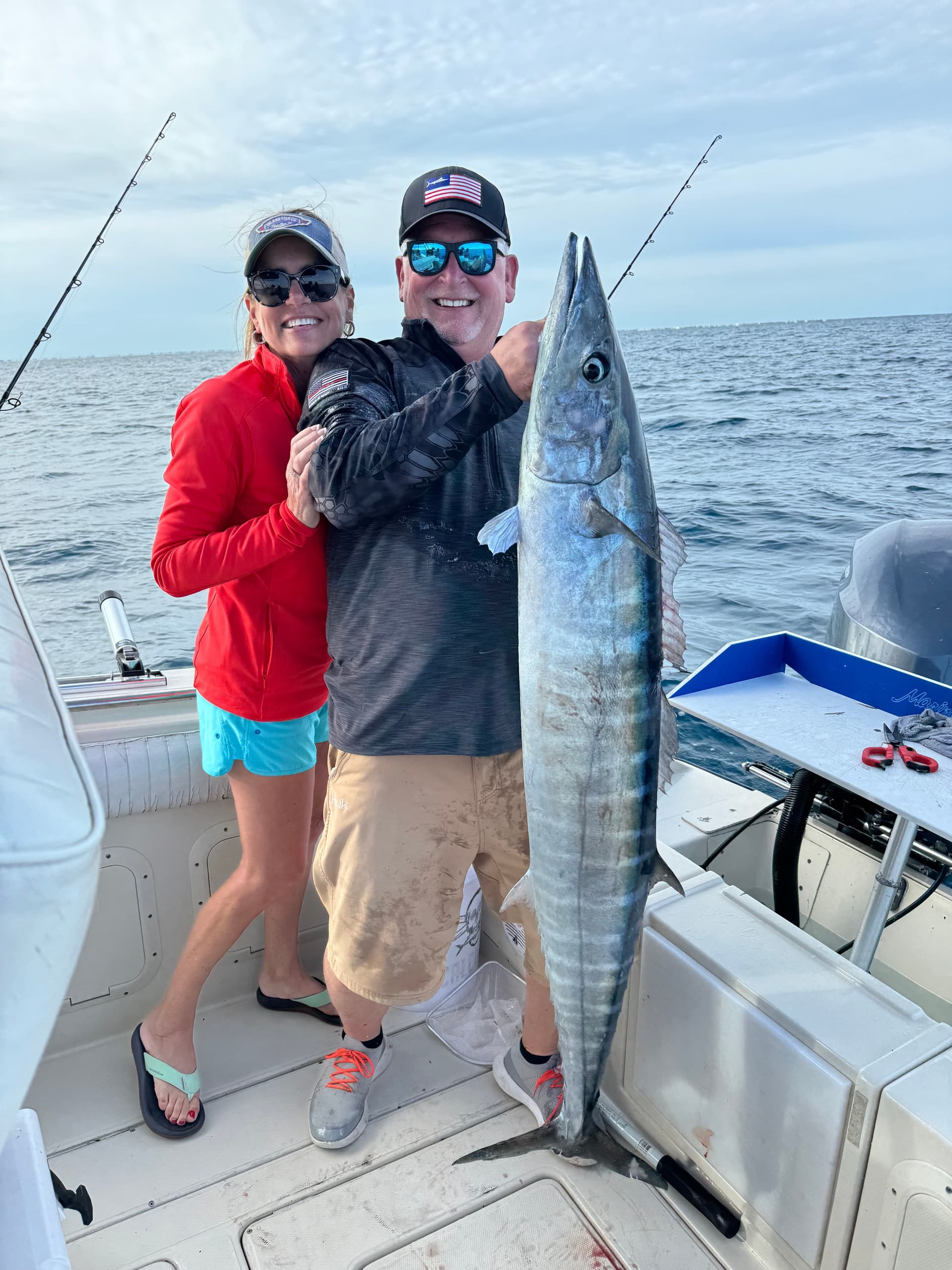 Anglers posing with large wahoo aboard offshore fishing charter