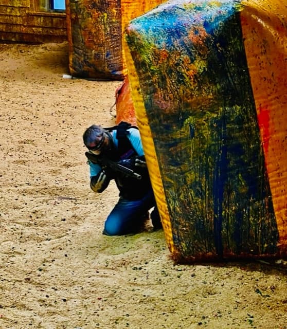 Player hiding behind paint-splattered bunker during match