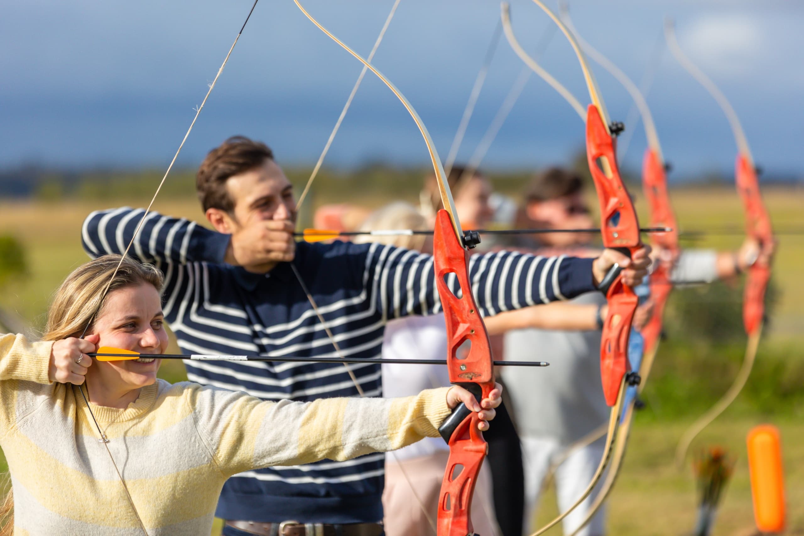 Group archers shooting on open field range during lesson