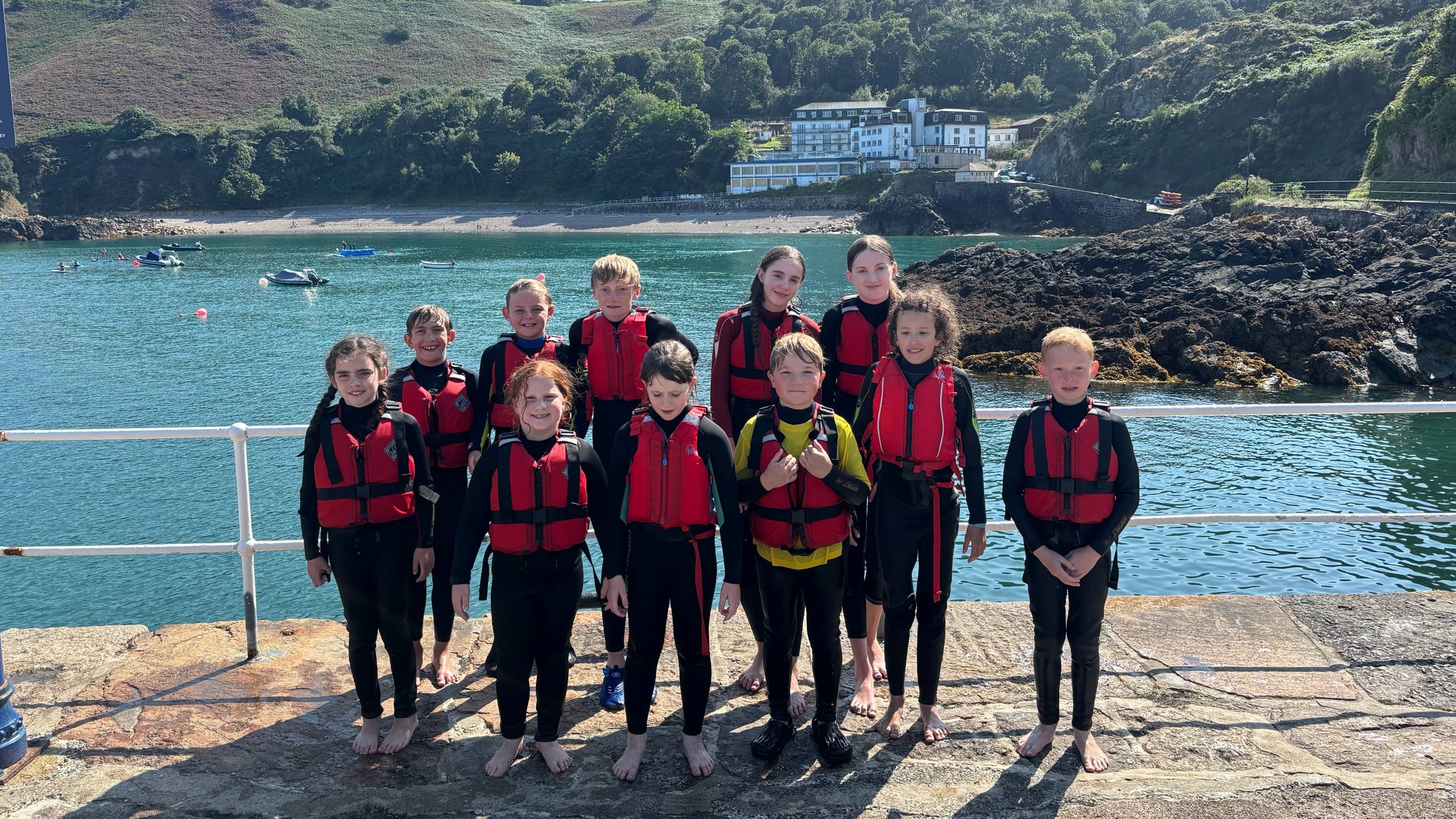 Group in life jackets on harbor pier before coastal kayaking