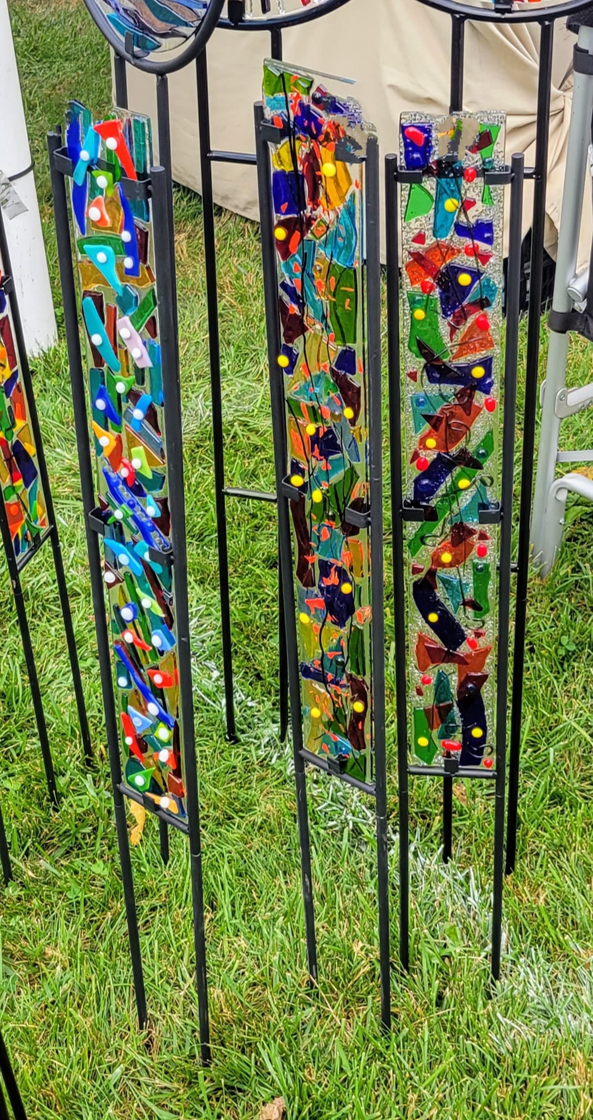 Colorful fused-glass garden stakes installed in grassy yard