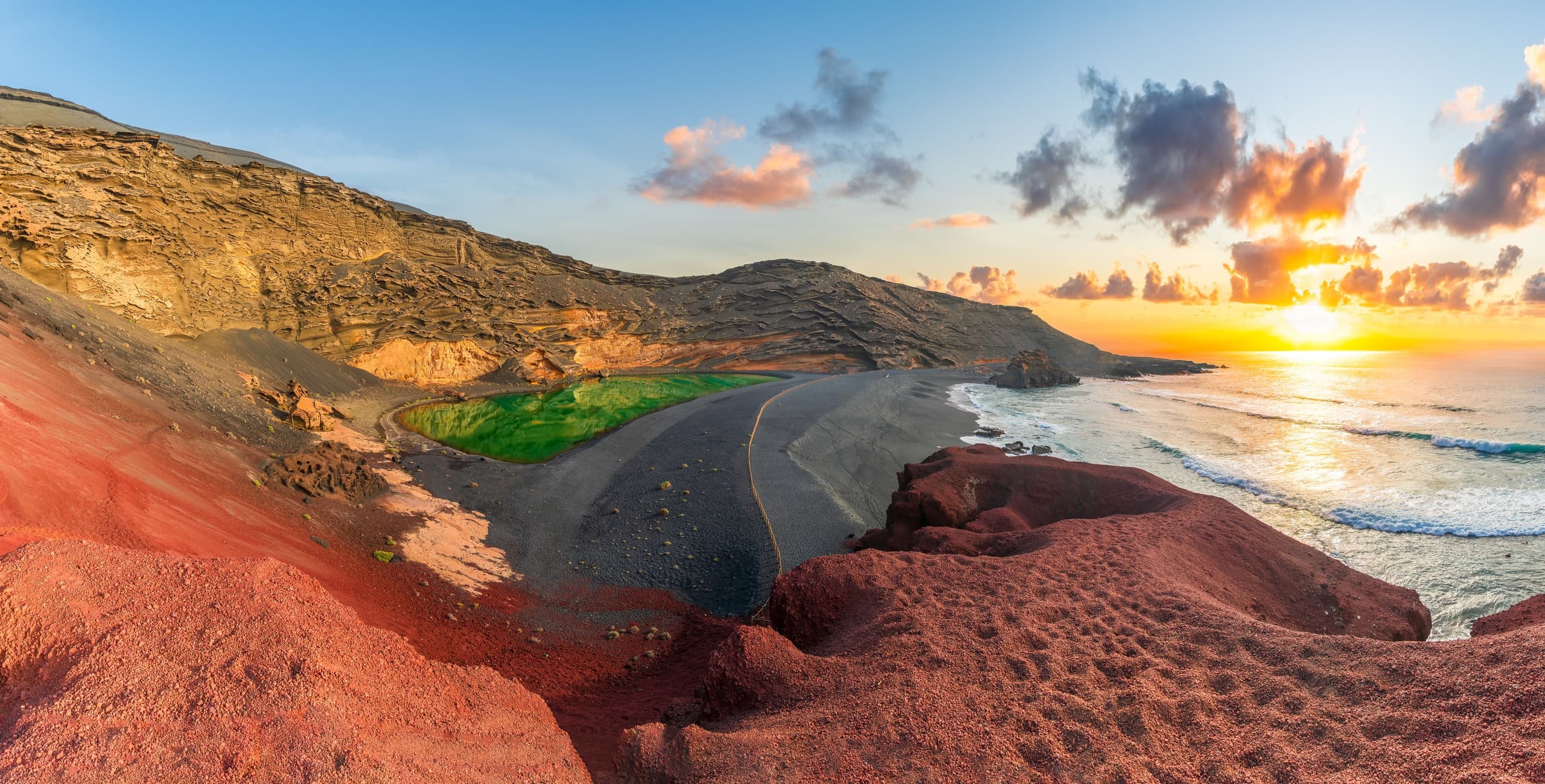Sunset coastal hike along red volcanic cliffs and ocean shore