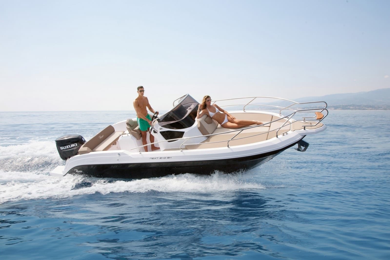 Couple on bow of leisure motorboat cruising calm sea